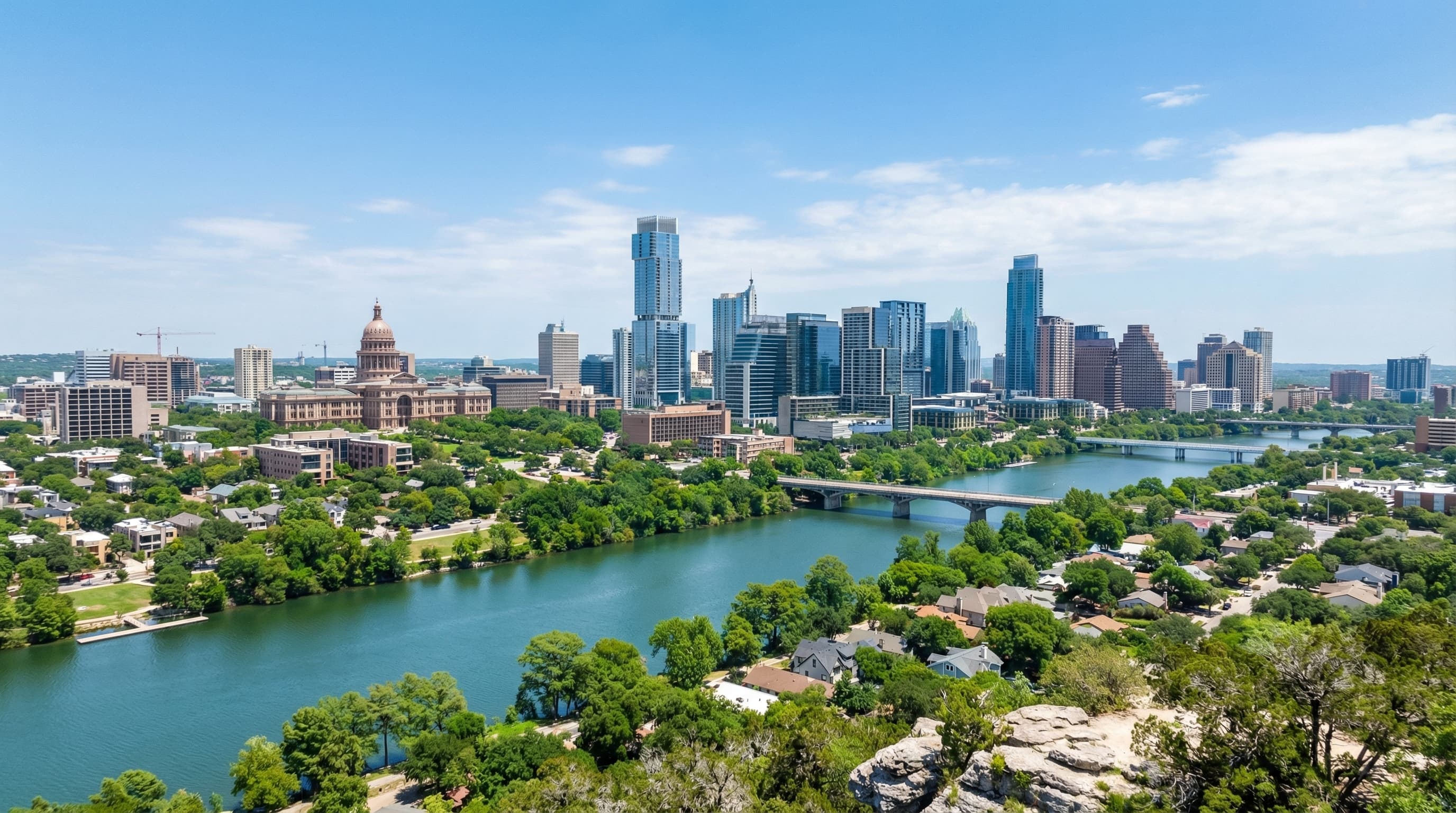 Aerial view of Austin Texas skyline with Lady Bird Lake, Texas State Capitol, and Hill Country at sunset