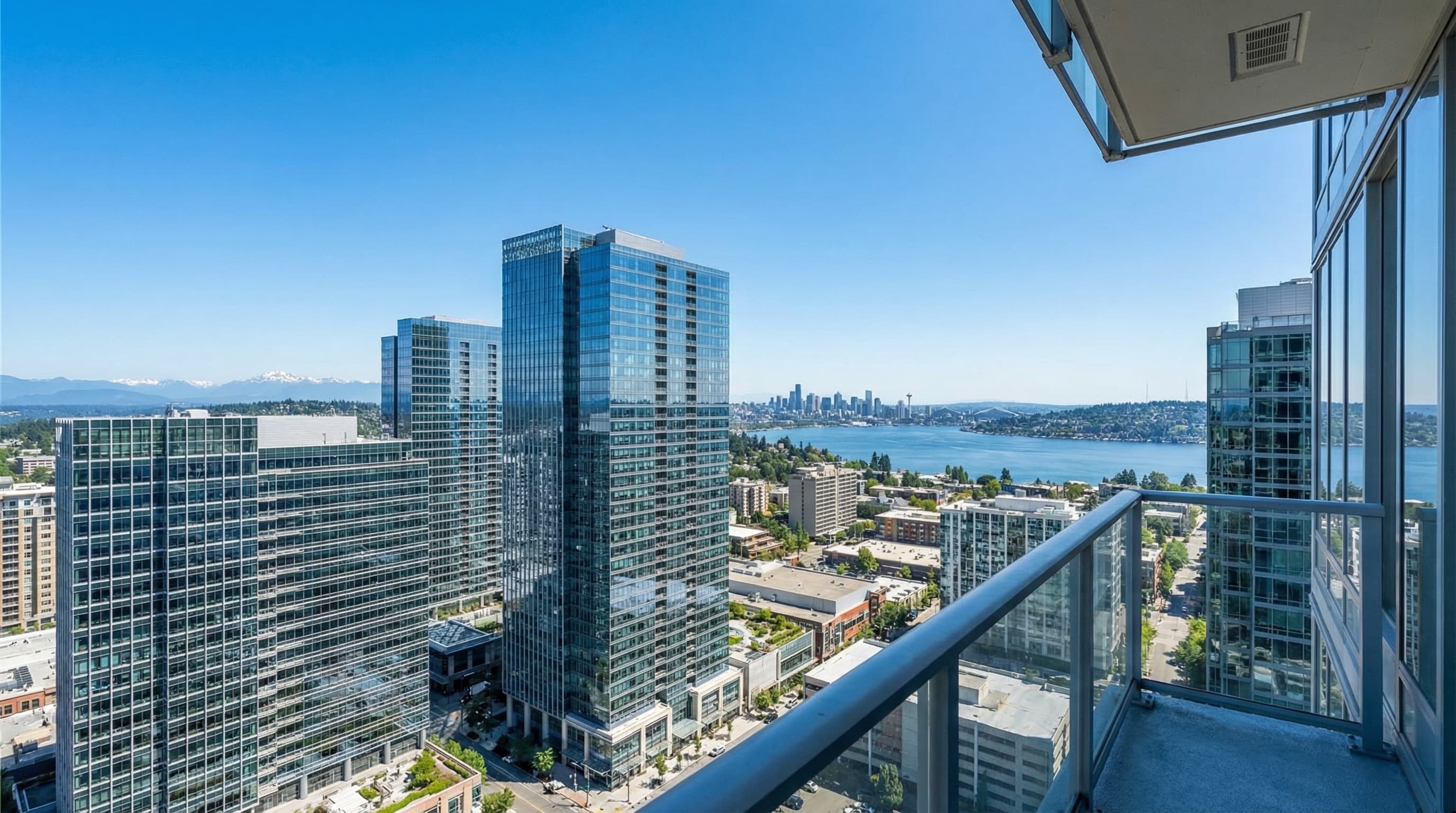Bellevue Washington skyline with Lake Washington waterfront, luxury high-rises, and Cascade Mountain backdrop