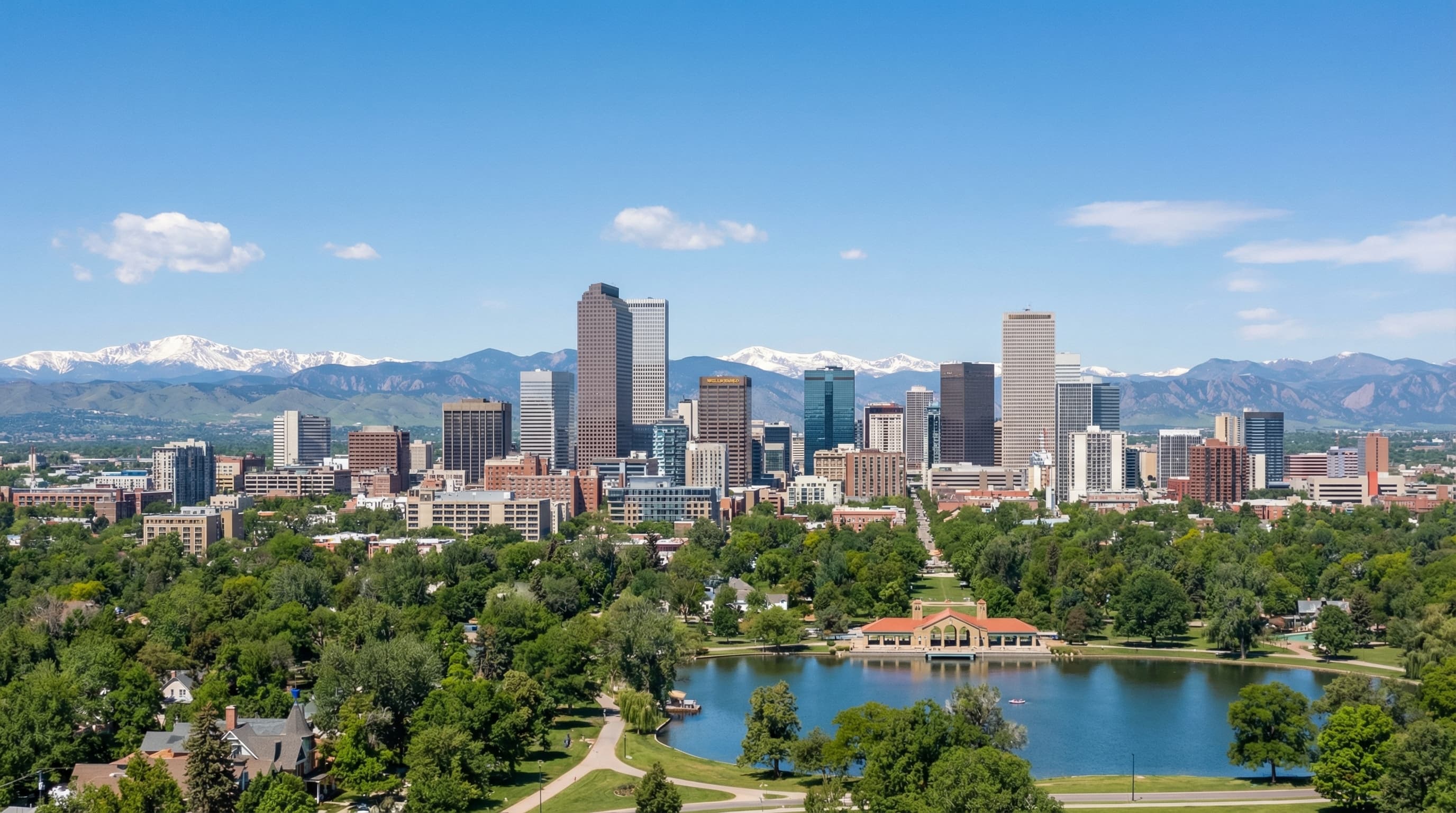 Aerial view of Denver Colorado skyline with Rocky Mountain backdrop, downtown skyscrapers, and clear blue Colorado sky