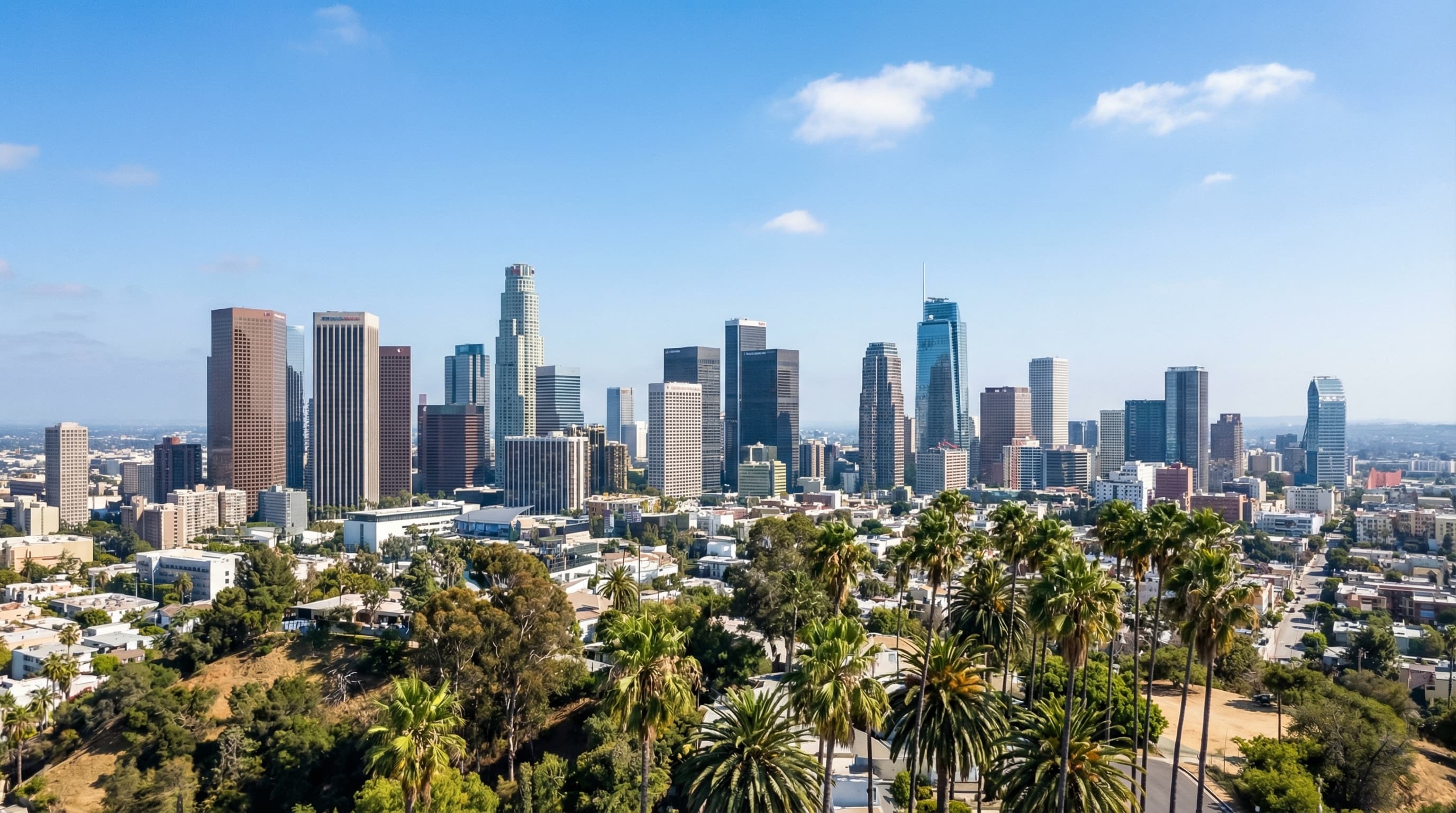 Aerial drone view of Los Angeles skyline from Griffith Observatory with Hollywood Hills and palm trees