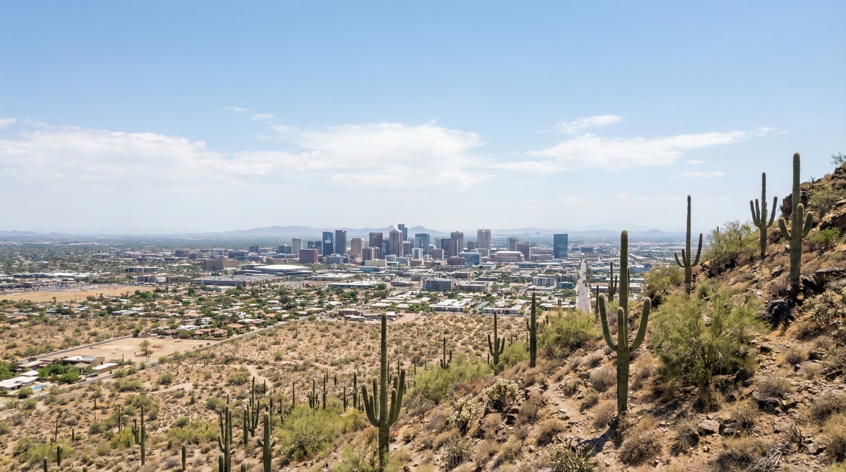 Aerial drone view of Phoenix Arizona skyline from Camelback Mountain with Sonoran Desert saguaro cacti and downtown valley