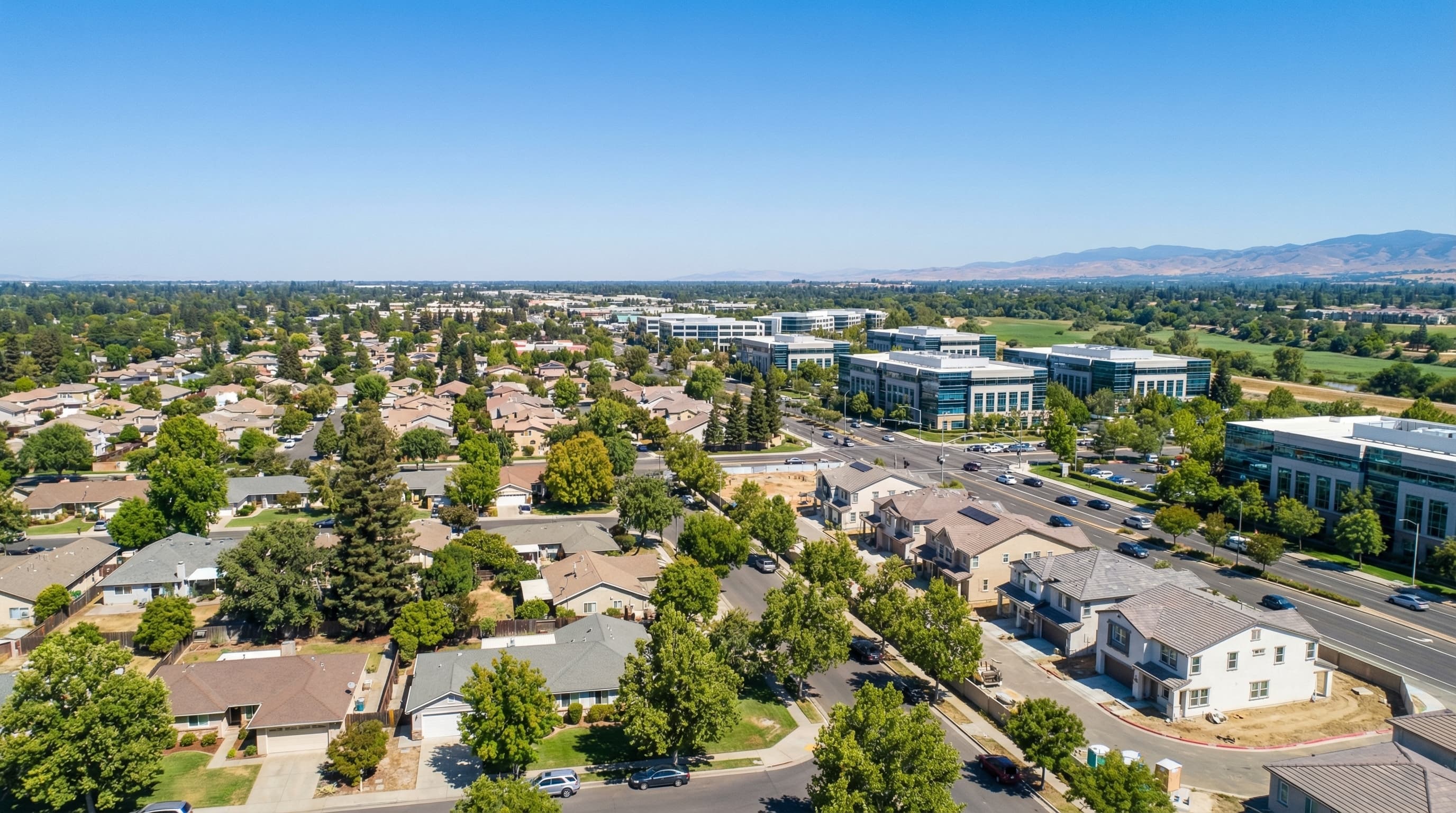 Growing Rancho Cordova California suburban area with mix of established and new construction homes, business parks, and tree-lined streets near American River Parkway